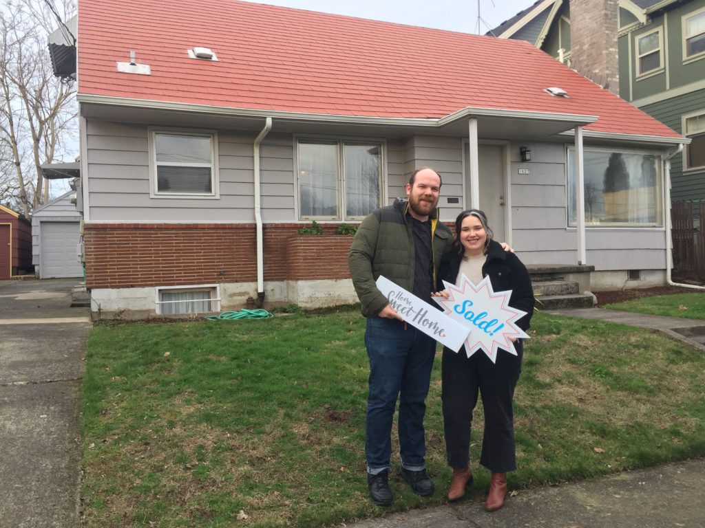 First time buyers in front of their first home in Sellwood.